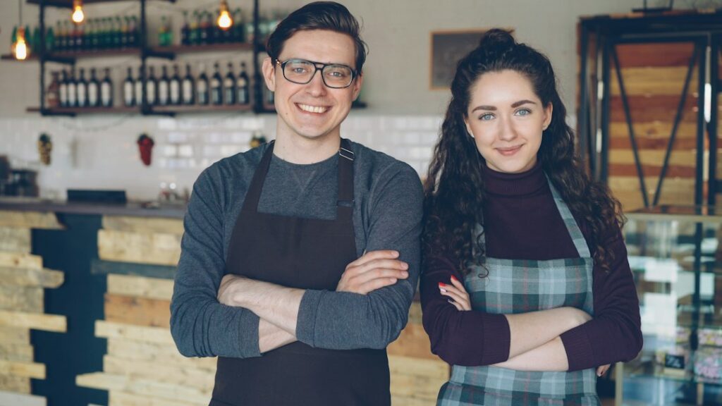 Two multicultural coffee shop owners standing together in their shop